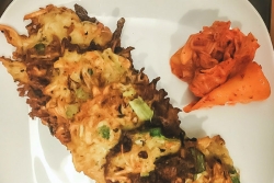 Potato latkes with kimchi on a white plate 